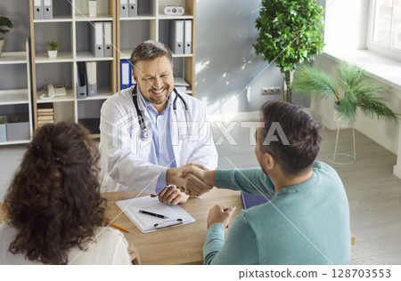 Doctor meets, agrees, congratulating patients in clinic centre, consulting family couple, counseling 128703553