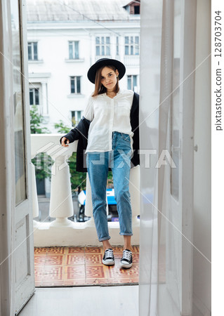 Beautiful fashionable brunette woman in jacket and hat posing in the background 128703704