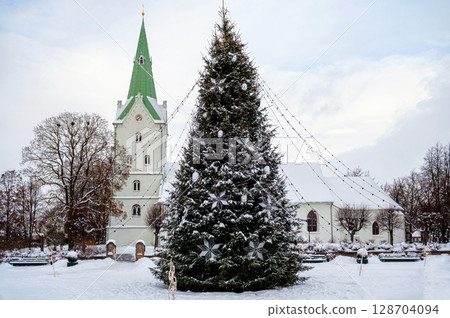 A decorated Christmas tree in a town square with a church in the background, Dobele, Latvia 128704094