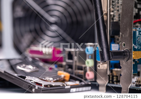 part of computer circuit board with components on the background of defocused power supply fans, close-up part of computer circuit board with components on the background of defocused power supply fans, close-up 128704115