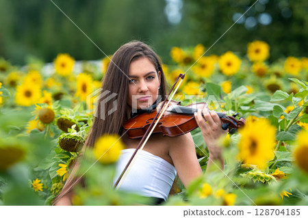 beautiful slim teenager woman with violin in yellow blooming sunflower field 128704185