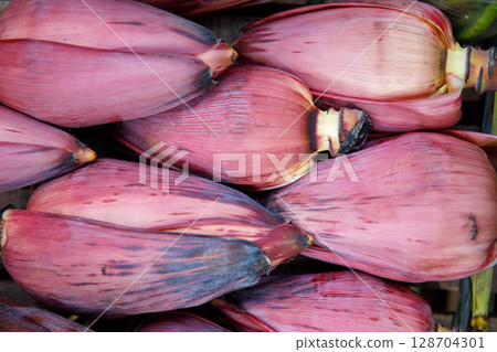 Banana blossoms freshly harvested and displayed for sale at a local market in Southeast Asia. 128704301