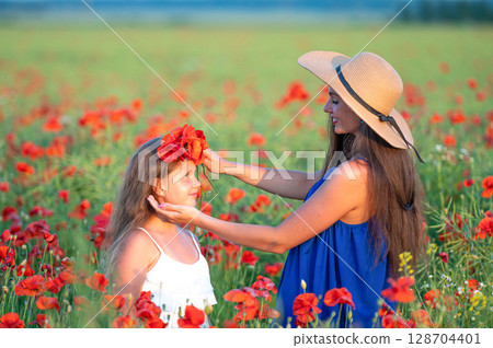 elegant young woman with child girl in poppy field, happy family having fun in nature, summer time elegant young woman with child girl in poppy field, happy family having fun in nature, summer time 128704401