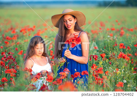 beautiful young woman with girl in straw hats in poppy field, happy family having fun in nature beautiful young woman with girl in straw hats in poppy field, happy family having fun in nature 128704402