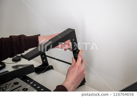 person adjusting ergonomic metal laptop stand on white desk in home office  128704656