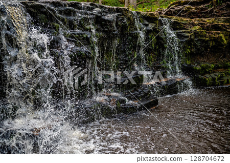 beautiful view in spring of a waterfall on small river Ivande in Latvia 128704672