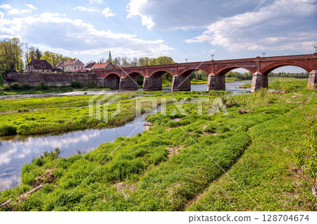 The old red brick bridge across the Venta river, built in 1874, Kuldiga, Latvia 128704674
