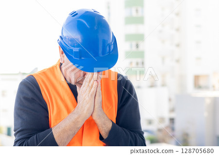 Construction engineer suffering from headache 128705680