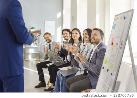 Business team applauding speaker during presentation, showing approval and interest in discussion. Business team applauding speaker during presentation, showing approval and interest in discussion. 128705756