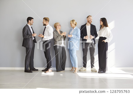 Diverse Business Team Communicating In Office On Gray Background Diverse Business Team Communicating In Office On Gray Background 128705763