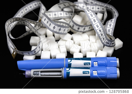Insulin injection pen on a dark background for diabetics and weight loss. 128705868