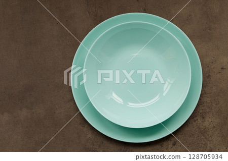 blue plates of different sizes and shapes on a gray background blue plates of different sizes and shapes on a gray background 128705934