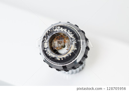 Old faucet aerator close-up on a white background. Broken sink mixer 128705956