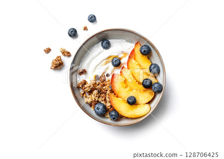Granola bowl with greek yogurt, peach and blueberries isolated 128706425