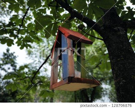 Wooden bird feeder with house sparrow and sparrow Bird feeder, feeding for birds. Bird feeder on a tree Wooden bird feeder with house sparrow and sparrow Bird feeder, feeding for birds. Bird feeder on a tree 128706876
