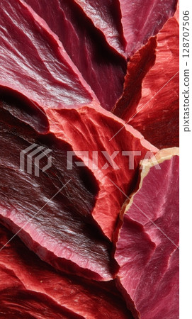 Oxblood mineral layers in macro view with sharp peaks and organic glossy texture 128707506