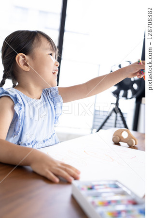 Educational scene of a girl enjoying drawing with crayons 128708382