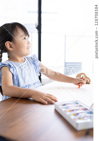 Educational scene of a girl enjoying drawing with crayons 128708384