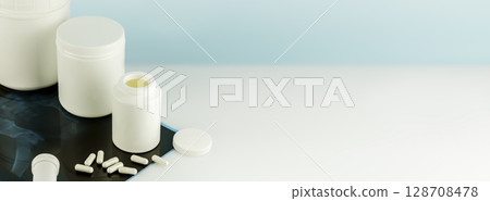 Calcium Ca supplements for Bone human health. Bone and joint health. Mockup of supplements for skin, bones and joints. White bottles with capsules and X-ray film. Banner size, copy space Calcium Ca supplements for Bone human health. Bone and joint health. Mockup of supplements for skin, bones and joints. White bottles with capsules and X-ray film. Banner size, copy space 128708478