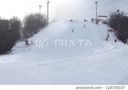 City park. Slope of the hill of Protasiv Yar, winter cloudy sky people skiing. Kyiv, Ukraine City park. Slope of the hill of Protasiv Yar, winter cloudy sky people skiing. Kyiv, Ukraine 128708587