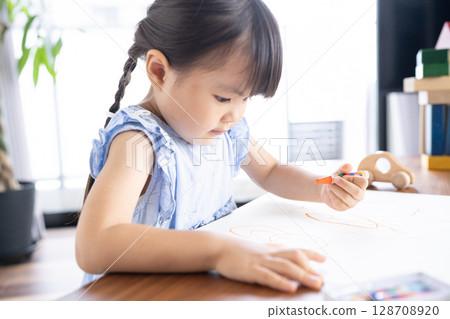 Educational scene of a girl enjoying drawing with crayons 128708920