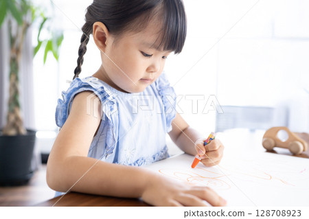 Educational scene of a girl enjoying drawing with crayons 128708923