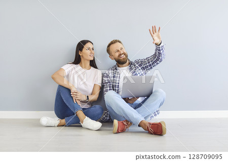 Happy family couple sitting on floor at home and planning improvements and renovations 128709095