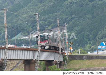 【廣島可部線】JR227系列車（紅翼號）在青山環繞的鐵橋上行駛 128709286
