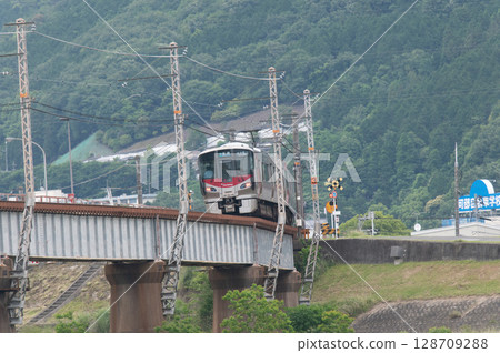 【廣島可部線】JR227系列車（紅翼號）在青山環繞的鐵橋上行駛 128709288