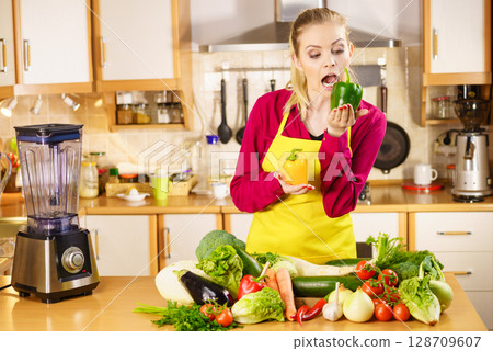 Funny woman taking bite of bell pepper 128709607
