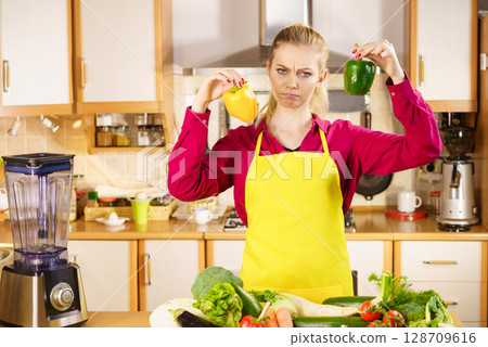 Woman holding bell peppers paprika thinking 128709616
