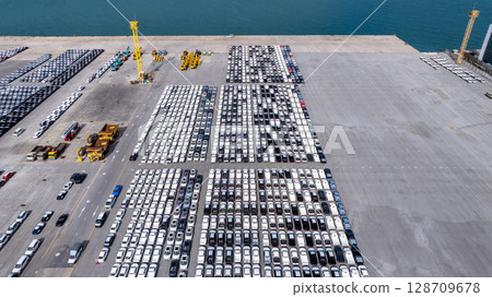 Aerial view new cars at industrial international sea port, Global business import export new cars logistic transportation, New cars line up parking lot for import export. 128709678