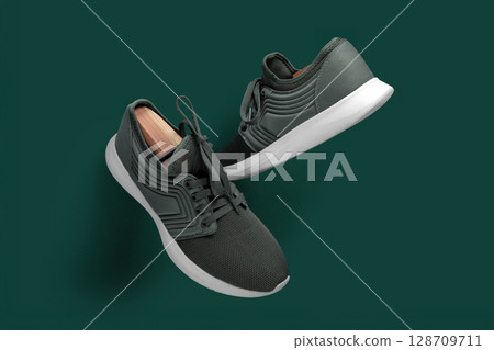 Modern Green Running Sneakers with White Soles on Green Background Modern Green Running Sneakers with White Soles on Green Background 128709711