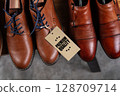 Premium Leather Shoes with Quality Tag on Wooden Shelf 128709714