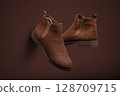 Stylish Brown Suede Chelsea Boots on Monochromatic Background 128709715