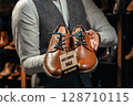 Salesman Holding Brown Leather Shoes with Discount Tag 128710115