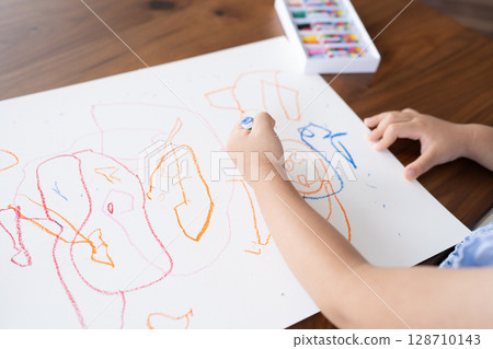A close-up of an educational scene of a girl enjoying drawing with crayons 128710143