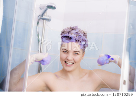 Woman applying toner shampoo on her hair 128710299