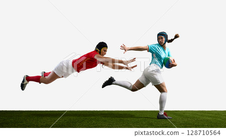 Two female rugby players in action on a green field against white background 128710564