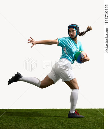 Athletic woman playing rugby holding ball running on field 128710565