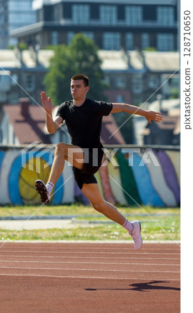 Athlete in mid-air leap while sprinting on sunny outdoor track Athlete in mid-air leap while sprinting on sunny outdoor track 128710650