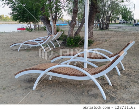 Sunbeds on a sandy beach. Central beach in Kostanay. 128711162