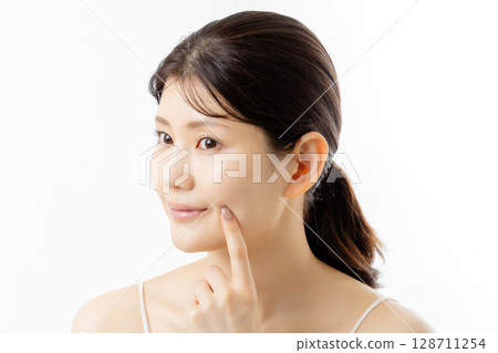 擔心皮膚問題的年輕女性的面部表情(白色背景) 擔心皮膚問題的年輕女性的面部表情(白色背景) 128711254
