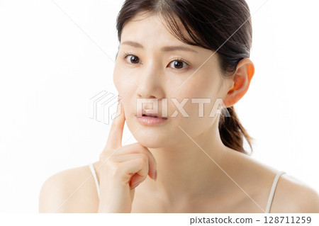擔心皮膚問題的年輕女性的面部表情（白色背景） 128711259