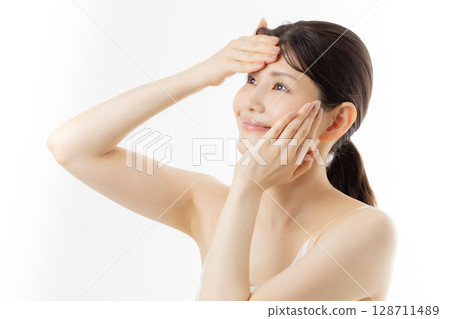 一名年輕女子正在做皮膚護理 一名年輕女子正在做皮膚護理 128711489