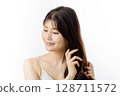 Young woman taking care of her hair 128711572