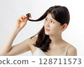 Young woman taking care of her hair 128711573