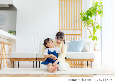 Parents and children relaxing in the living room Parents and children relaxing in the living room 128711626