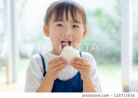 A girl who eats onigiri 128711638