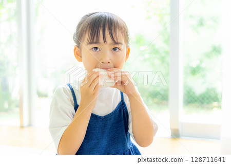 A girl who eats onigiri 128711641
